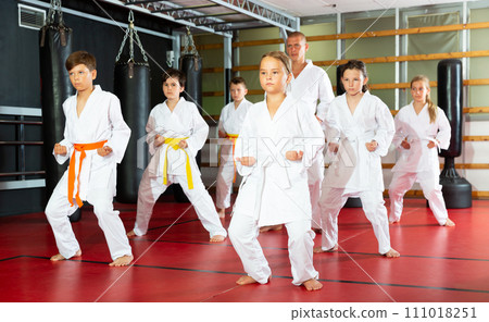 Karate kids in kimono performing kata moves Karate kids in kimono performing kata moves 111018251