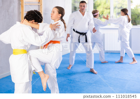 Children athletes in pair conduct training battle in oriental fighting technique 111018545