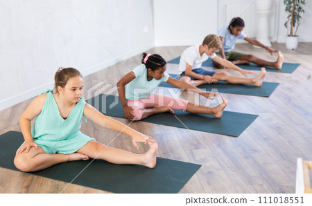 Girl stretches and prepares to perform Jana Shirshasana Girl stretches and prepares to perform Jana Shirshasana 111018551