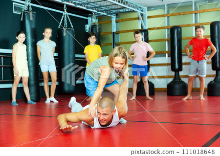 Children practice self-defense techniques on coach 111018648