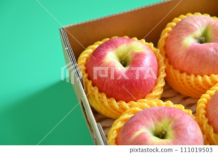 beautiful pink apple in the box on green background, healthy fruit beautiful pink apple in the box on green background, healthy fruit 111019503