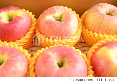 beautiful pink apple in yellow wrap bubble, healthy fruit in the box 111019505