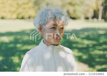 Woman in her 60s in the park 111019801