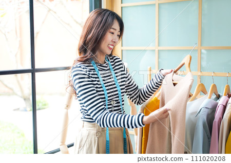 Young women fashion designer using laptop working and design tailor and cloth in the showroom, Young women fashion designer using laptop working and design tailor and cloth in the showroom, 111020208