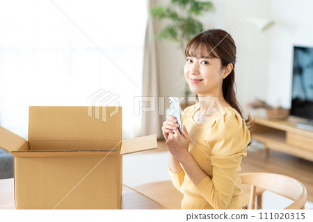 一個女人在客廳裡收拾紙板 111020315