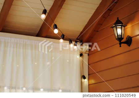 Illuminated string lights on a wooden patio. Illuminated string lights on a wooden patio. 111020549