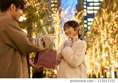 男人和女人手拿禮物，城市景觀被燈光照亮 111021252