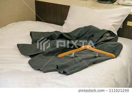 A suit jacket taken off on the bed A suit jacket taken off on the bed 111021299