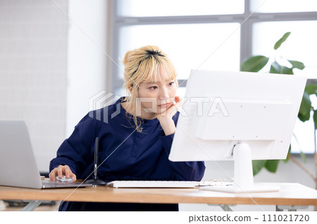 Business Young woman working on a computer Business Young woman working on a computer 111021720