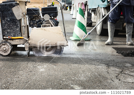 Road construction: Paving slab cutting work with a concrete cutter Road construction: Paving slab cutting work with a concrete cutter 111021789