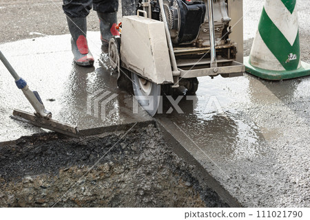 Road construction: Paving slab cutting work with a concrete cutter Road construction: Paving slab cutting work with a concrete cutter 111021790