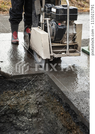 Road construction: Paving slab cutting work with a concrete cutter Road construction: Paving slab cutting work with a concrete cutter 111021791