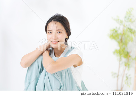 一名20多歲女性抱著膝蓋坐著的照片 一名20多歲女性抱著膝蓋坐著的照片 111021819