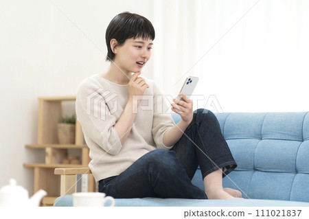 坐在沙發上使用智能手機的年輕女性 111021837