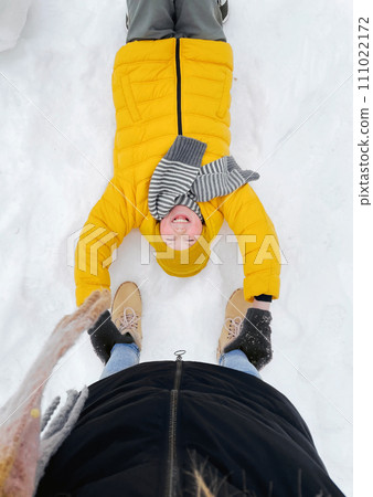 Top View on Laughing Kid Lying on Snow Top View on Laughing Kid Lying on Snow 111022172