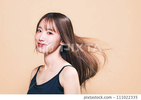 Image of hair care, cosmetics, and skin care of a woman with her hair blowing in the wind 111022335