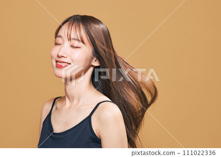 Image of hair care, cosmetics, and skin care of a woman with her hair blowing in the wind 111022336