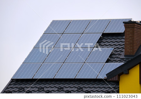 Private home roof covered with solar photovoltaic panels for generating of clean ecological electric energy in suburban rural town area. Concept of autonomous house 111023043