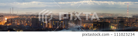 Panorama of night aerial view of Ivano-Frankivsk city, Ukraine. Scene of modern night city with bright lights of tall buildings. Residential quaters and construction cranes in modern urban space. Panorama of night aerial view of Ivano-Frankivsk city, Ukraine. Scene of modern night city with bright lights of tall buildings. Residential quaters and construction cranes in modern urban space. 111023234