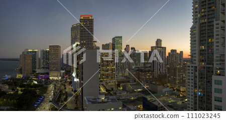View from above of brightly illuminated skyscraper buildings in downtown district of Miami Brickell in Florida, USA at night. American megapolis with business financial district 111023245