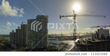 Aerial view of new developing residence in American urban area. Tower cranes at industrial construction site in Miami, Florida. Concept of housing growth in the USA 111023268