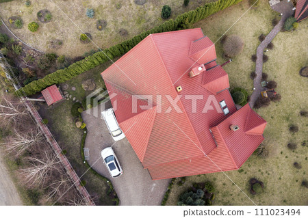 Aerial top view of new residential house cottage with shingle roof on fenced big yard on sunny day. 111023494