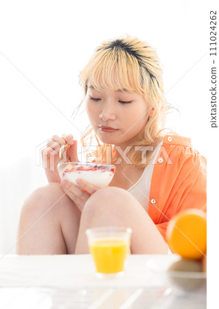 年輕的金髮女郎吃酸奶 111024262