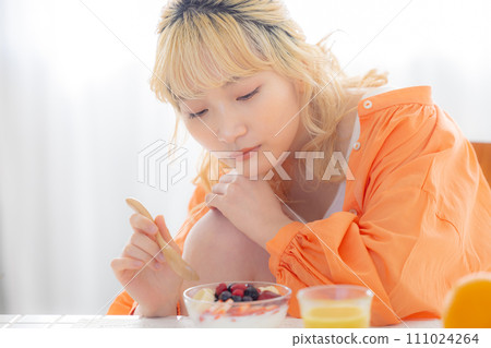 年輕的金髮女郎吃酸奶 111024264