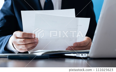 Businessman comparing documents and data 111025623