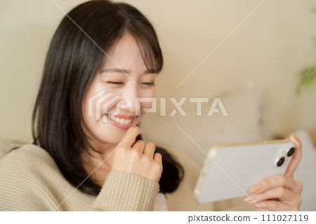 在床上使用智慧型手機的女人 111027119