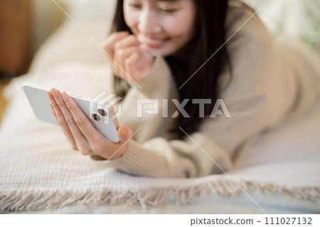 在床上使用智慧型手機的女人 111027132