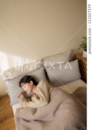 woman sleeping on bed in bedroom woman sleeping on bed in bedroom 111027374