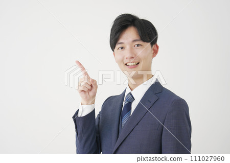 Young businessman pointing to the left, white background 111027960