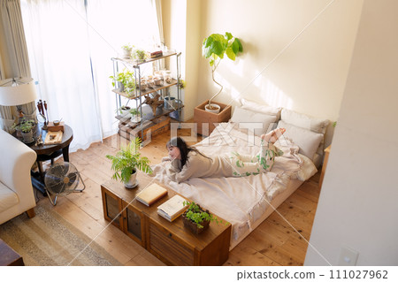 A woman relaxing on the bed A woman relaxing on the bed 111027962