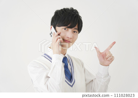High school boy giving a zip sign while calling on a smartphone, white background High school boy giving a zip sign while calling on a smartphone, white background 111028023