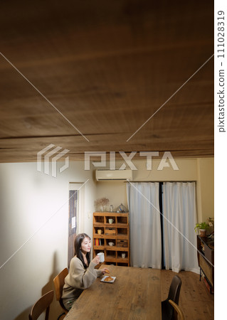 一位女士在客廳的餐桌上享用美食 一位女士在客廳的餐桌上享用美食 111028319