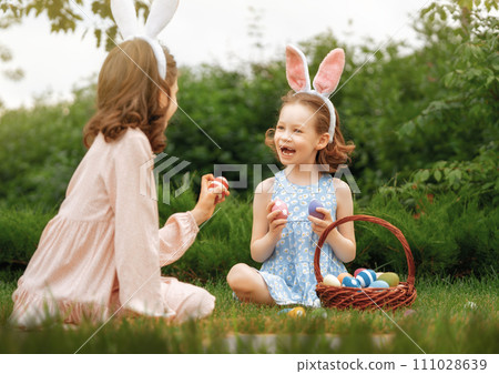 children with painting eggs outdoors 111028639