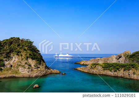 The beautiful Tomari Beach on Shikinejima and the Tokai Kisen Salvia Maru sailing offshore. At Nejima, Izu Islands, Tokyo. November 2023 The beautiful Tomari Beach on Shikinejima and the Tokai Kisen Salvia Maru sailing offshore. At Nejima, Izu Islands, Tokyo. November 2023 111029101