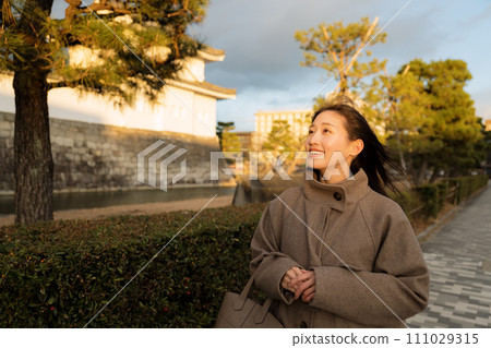 A woman walking in the city at sunset 111029315