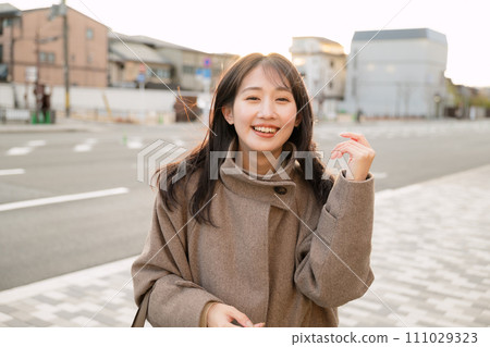 A woman walking in the city at sunset 111029323