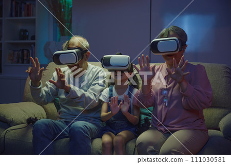 Asian elderly with child play VR video game, family entertainment, granddaughter and grandparents playing together exciting interesting video games using virtual reality headsets living room at home 111030581