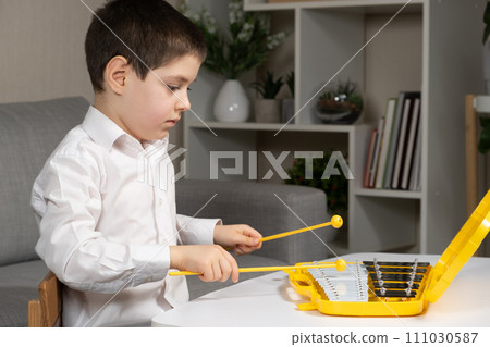 Little Six Year Old Boy Playing Metallophone Metal Xylophone Percussion Musical Instrument. Little Six Year Old Boy Playing Metallophone Metal Xylophone Percussion Musical Instrument. 111030587