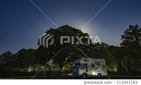 A camper that shines in the forest park under the starry sky A camper that shines in the forest park under the starry sky 111031163