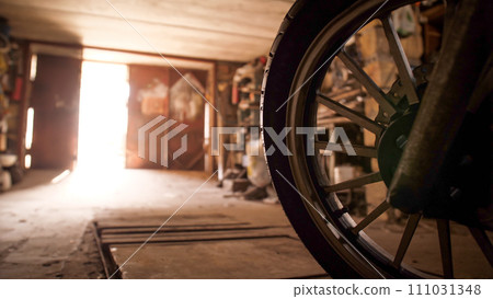 Shot of a wheel of the motorcycle part in the garage with opening door 111031348