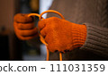 A hand's of a man in orange work gloves untangle orange wire 111031359