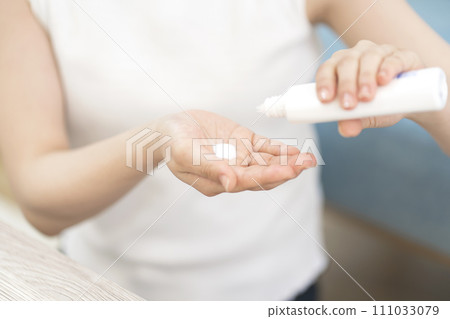 Young woman applying sunscreen Body parts Young woman applying sunscreen Body parts 111033079