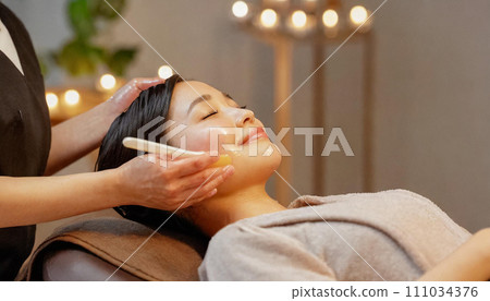 Woman receiving treatment at beauty salon, facial massage, oil massage 111034376