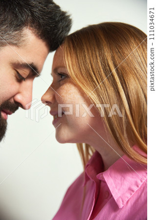 Close up photo of man and woman, wife and husband lovely looking to each other against white background. Romantic in relationship. 111034671