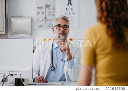 Portrait of doctor talking with tennage girl patient, during visit. Concept of preventive health care for adolescents. Portrait of doctor talking with tennage girl patient, during visit. Concept of preventive health care for adolescents. 111035800