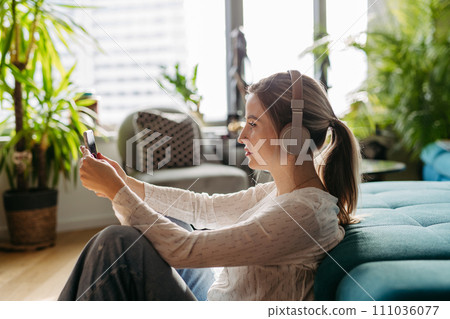 Female nurse or doctor enjoying free time at home after work, listening meditation relaxing music. Work-life balance for healthcare worker. 111036077